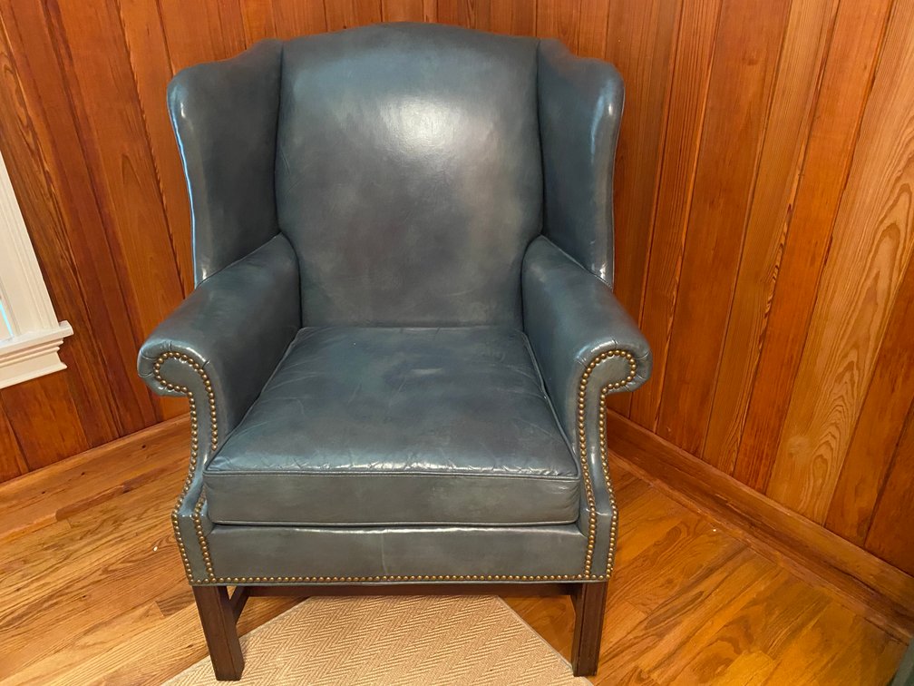 Blue Leather Wingback Arm Chair With Brass Nail Head Trim And Dark Wood Stretcher Base