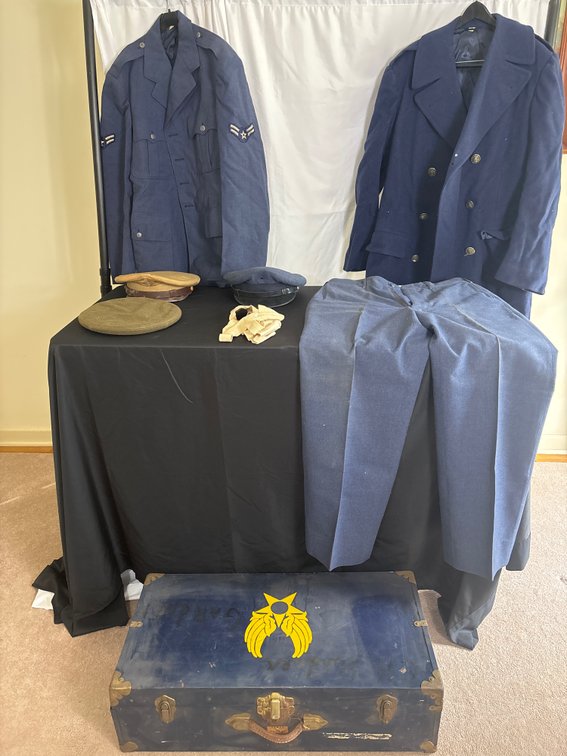 Large military memorabilia lot featuring a vintage dark blue Texas Trunk steamer trunk accompanied by a collection of U.S. Air Force uniform pieces.