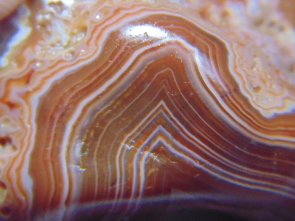 A 1 oz polished Lake Superior Agate with  banding and a crystal impression