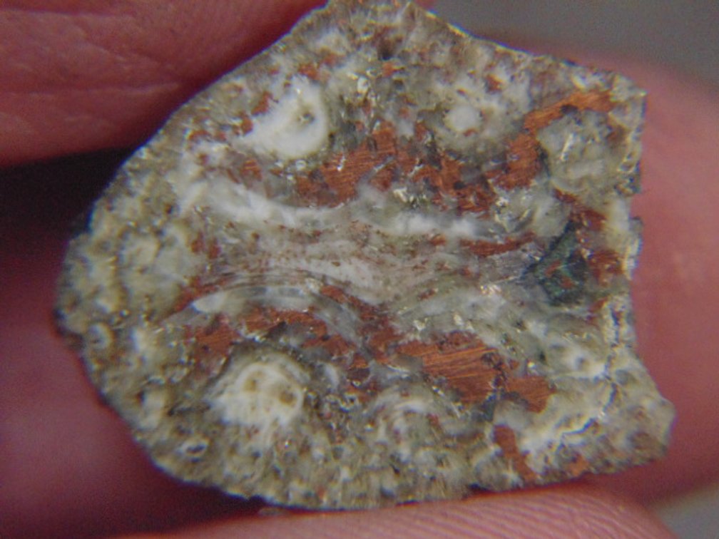 A face polished Copper Replacement Agate half, 3.1 grams