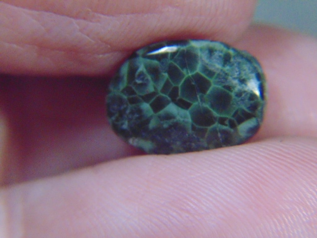 A face polished Greenstone cab, .5 grams