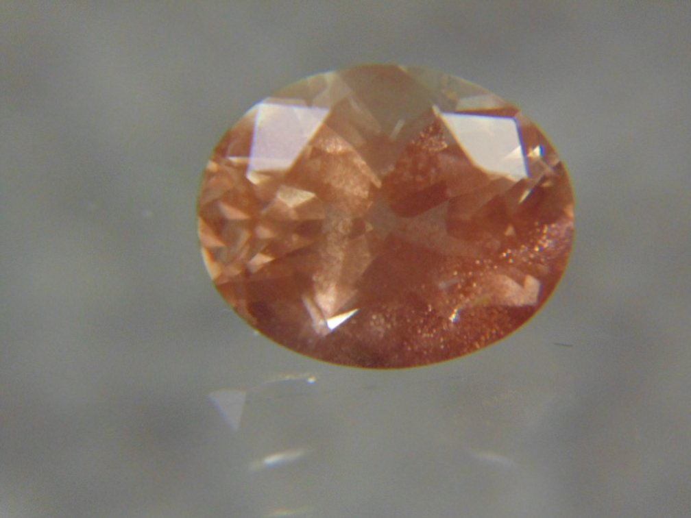 A oval faceted stone possibly Sunstone