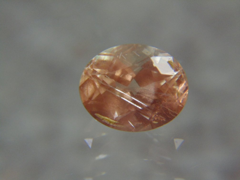 A oval faceted stone possibly Sunstone