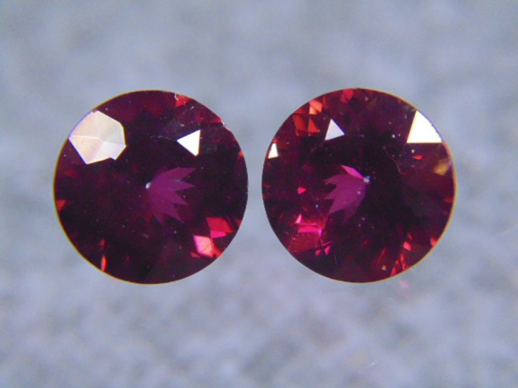 A pair of red faceted stones possibly Garnets