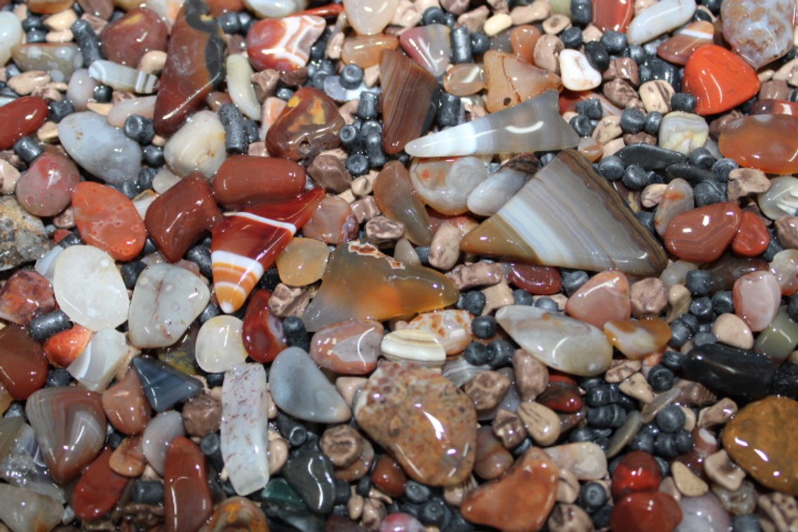 A 10 lb flat of mostly Lake Superior Agates with tumbling media. The agates have gone through the first stage of tumbling giving them a satin finish. They can either be left as is or put back into the tumbler for a high polish