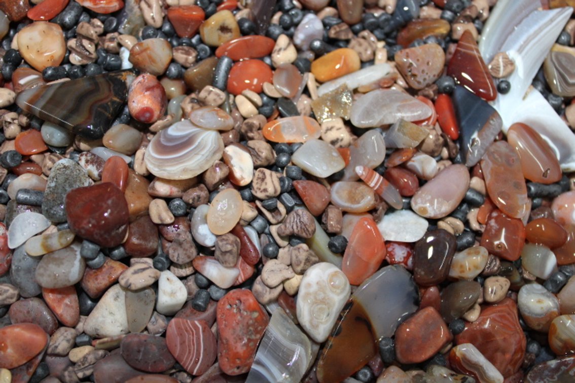 A 10 lb flat of mostly Lake Superior Agates with tumbling media. The agates have gone through the first stage of tumbling giving them a satin finish. They can either be left as is or put back into the tumbler for a high polish