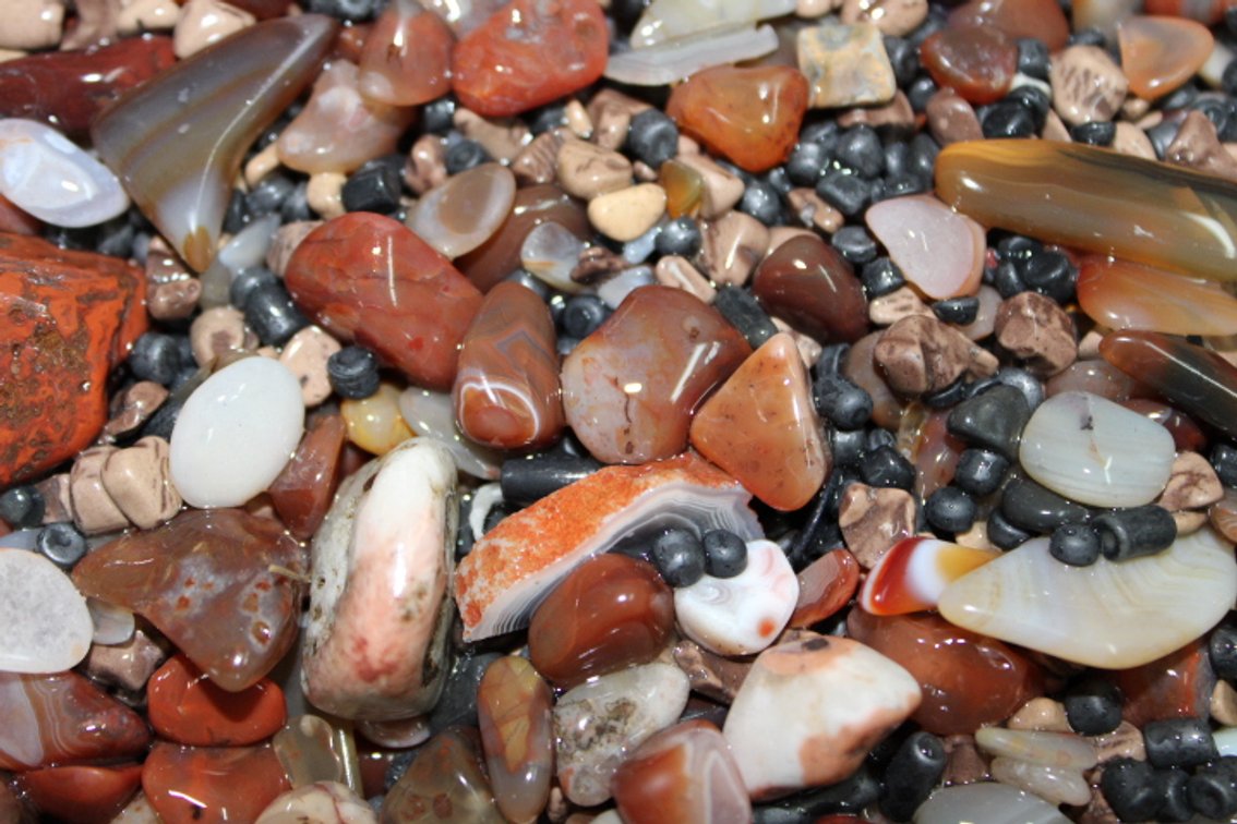 A 9 lb flat of mostly Lake Superior Agates with tumbling media. The agates have gone through the first stage of tumbling giving them a satin finish. They can either be left as is or put back into the tumbler for a high polish