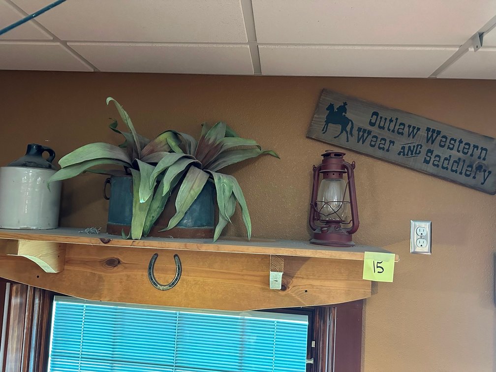 Shelf + jug + plant + lantern + Outlaw Western sign