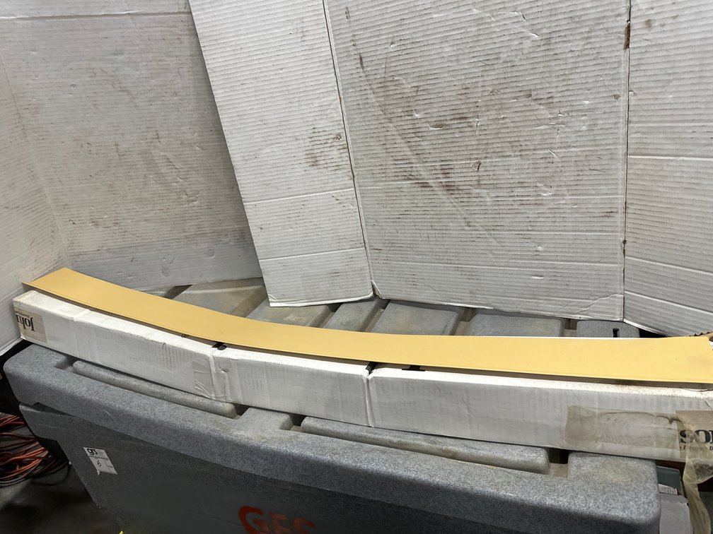 Vinyl Cove Base Molding and Stack of Curved Wooden Deck Blanks