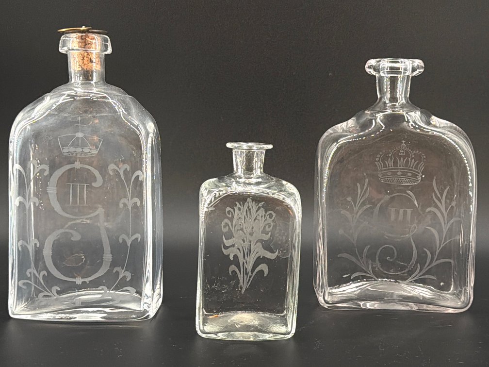 Trio of etched glass decanters; DEN