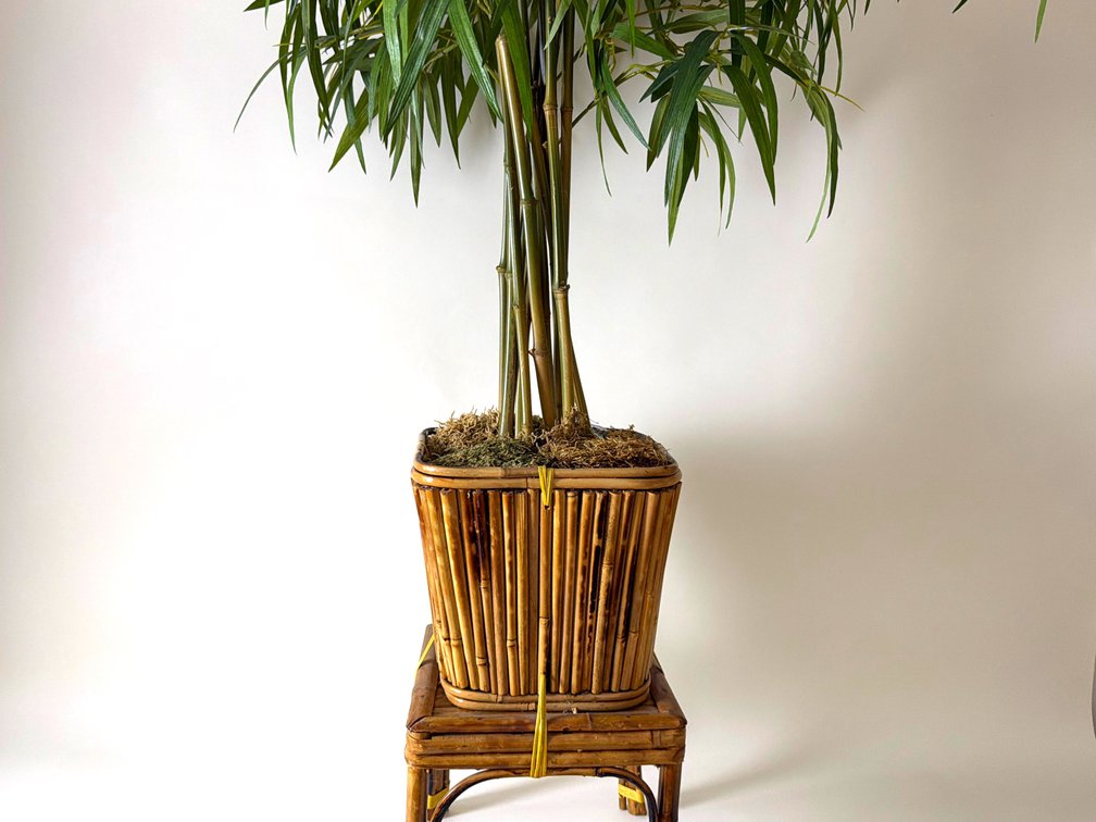 Artificial palm tree in decorative rattan planter stand; DEN