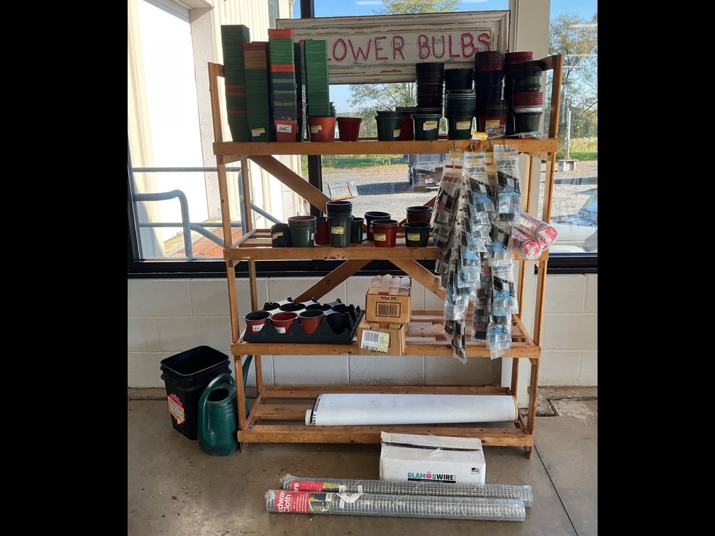 Wooden Shelving Unit with Garden Supplies and Fencing