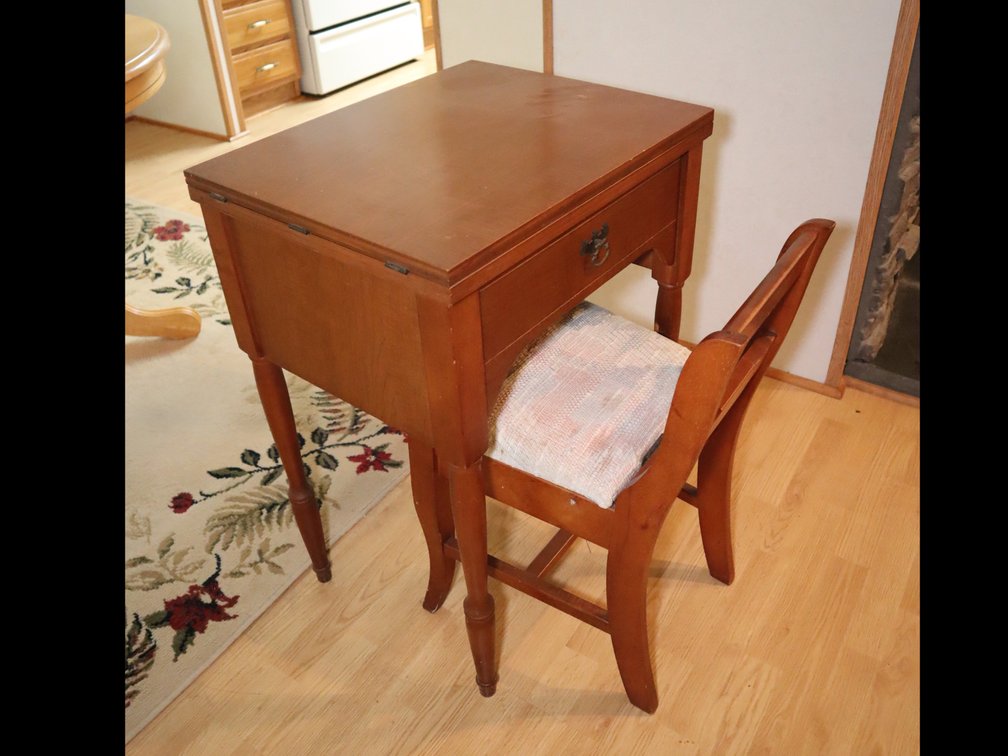 Wooden sewing machine cabinet with fold-out top, and matching upholstered seat chair