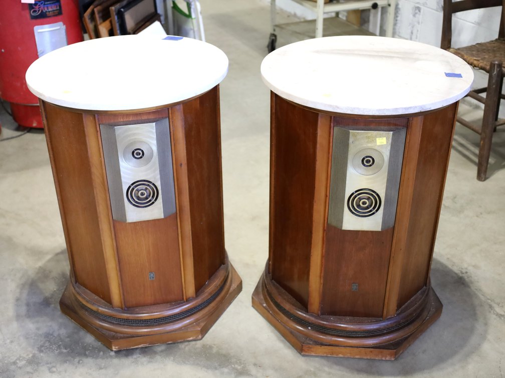 2 large round wooden speakers with marble tops