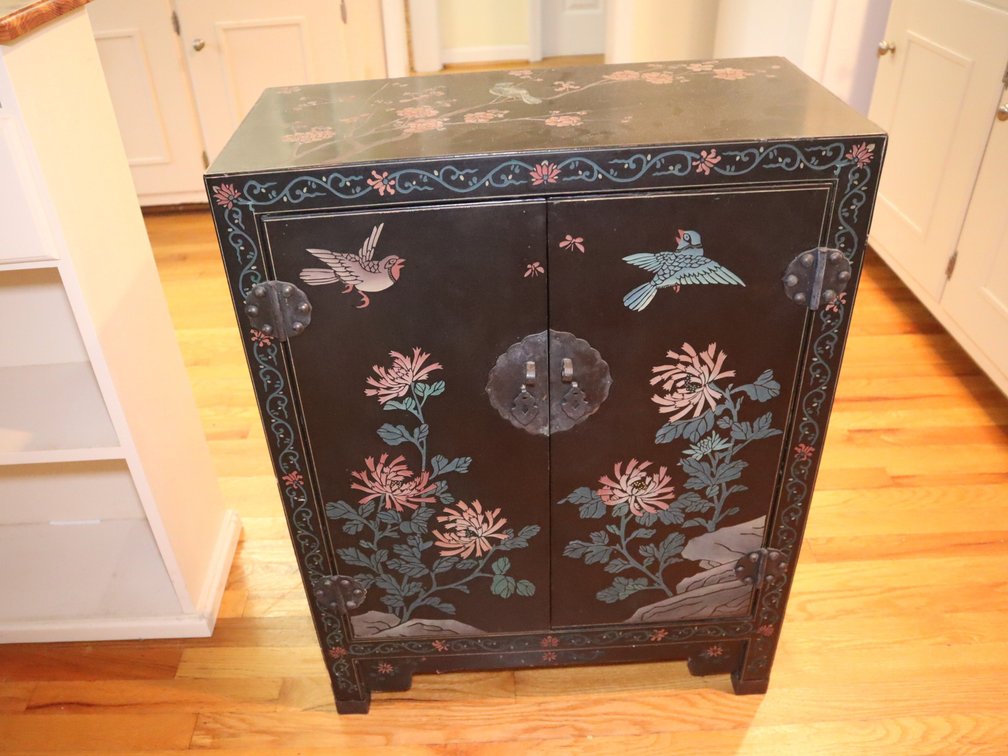 Black lacquer cupboard decorated with hummingbirds and leaves