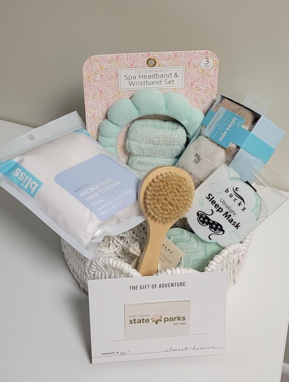 Spa Basket includes spa headband and wristband set, microfiber hair turban duo, three pairs of ultra plush crew socks, ultralight sleep mask, lotus wood bath brush, and $100 West Virginia State Parks Gift Card; Donated by CNB Bank