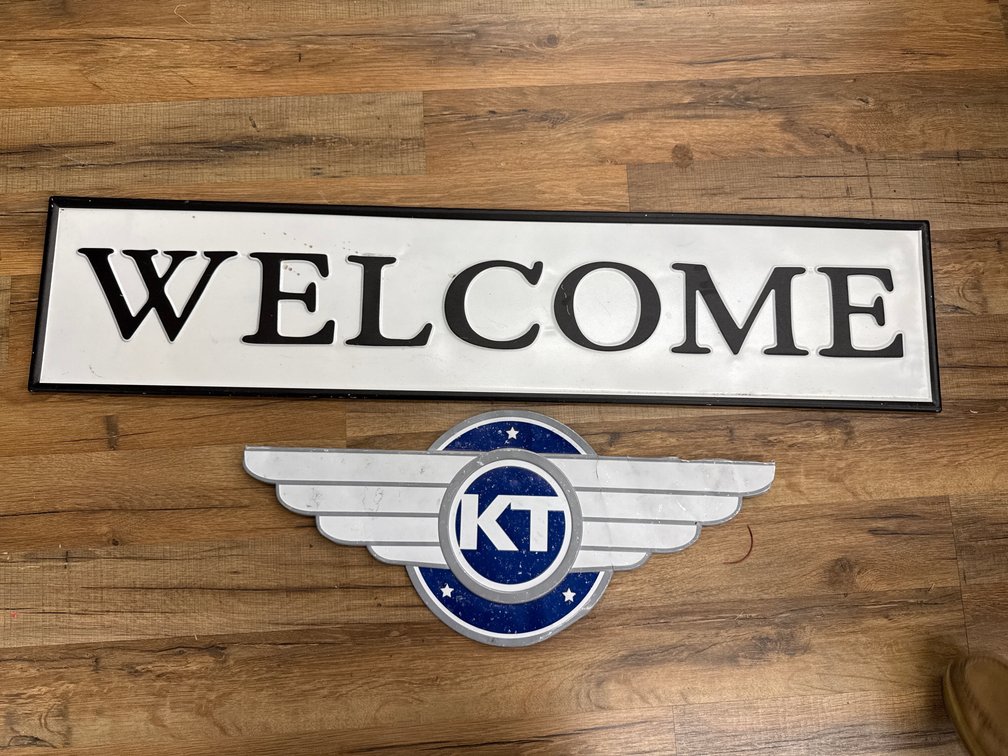 Embossed Metal Welcome Sign and Winged KT Logo Sign (2)