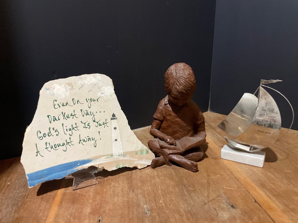 Painted Stone Plaque, Sailboat Sculpture, and Child Figurine