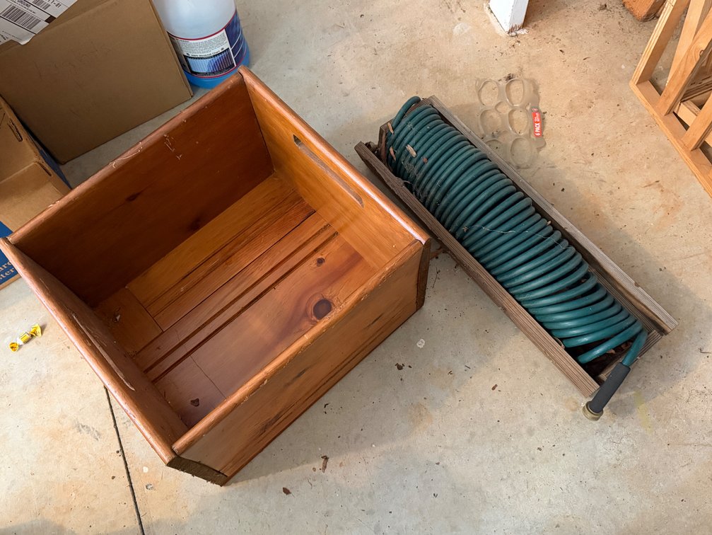 Wooden Storage Crate and Coiled Garden Hose