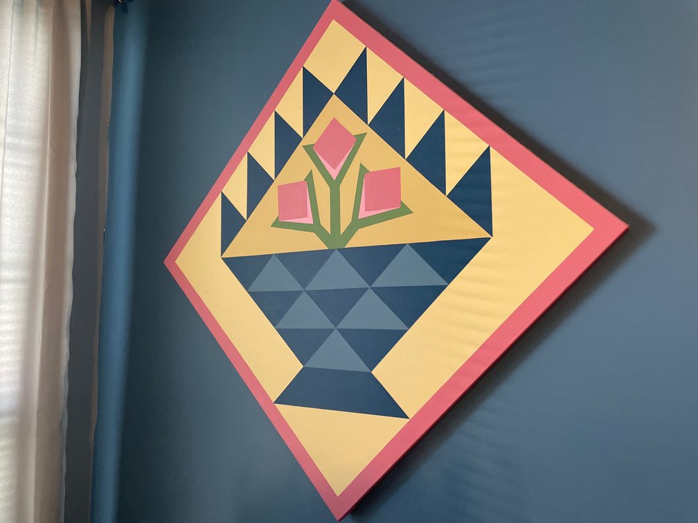 Painted Canvas Quilt Block Art and Wooden Rocking Chair