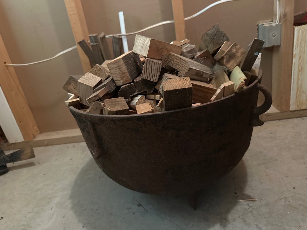 Cast Iron Three-Legged Cauldron and Drum of Wood Scraps