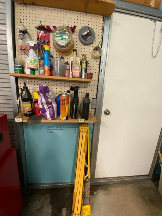 Contents of wall pegboard:  Grass and weed killer, anti-freeze, weed eater string, gear oil, fold-out sawhorses