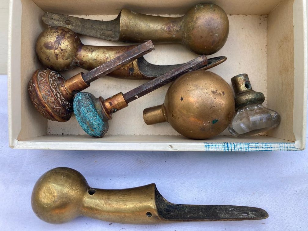 Lot of brass and glass doorknobs, and horse hames tops