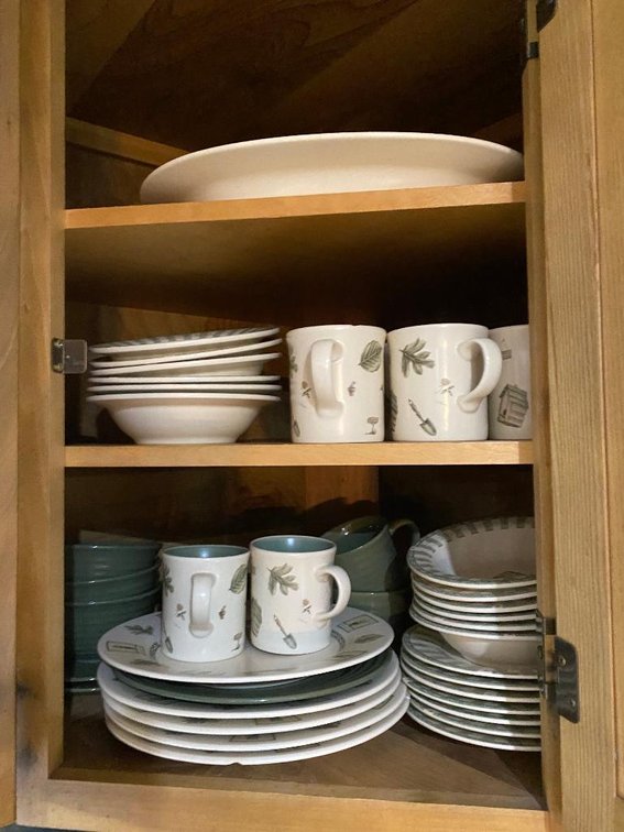 Contents of 4 cabinets:  Set of pottery dishes, some glassware, decorator, salt & pepper shakers, etc.