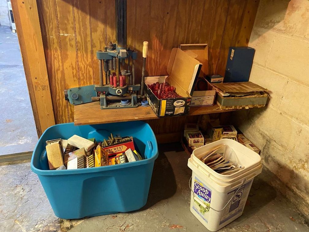 Bullet reloading kits, empty brass and plastic shelves.  Reloader is made by Bair
