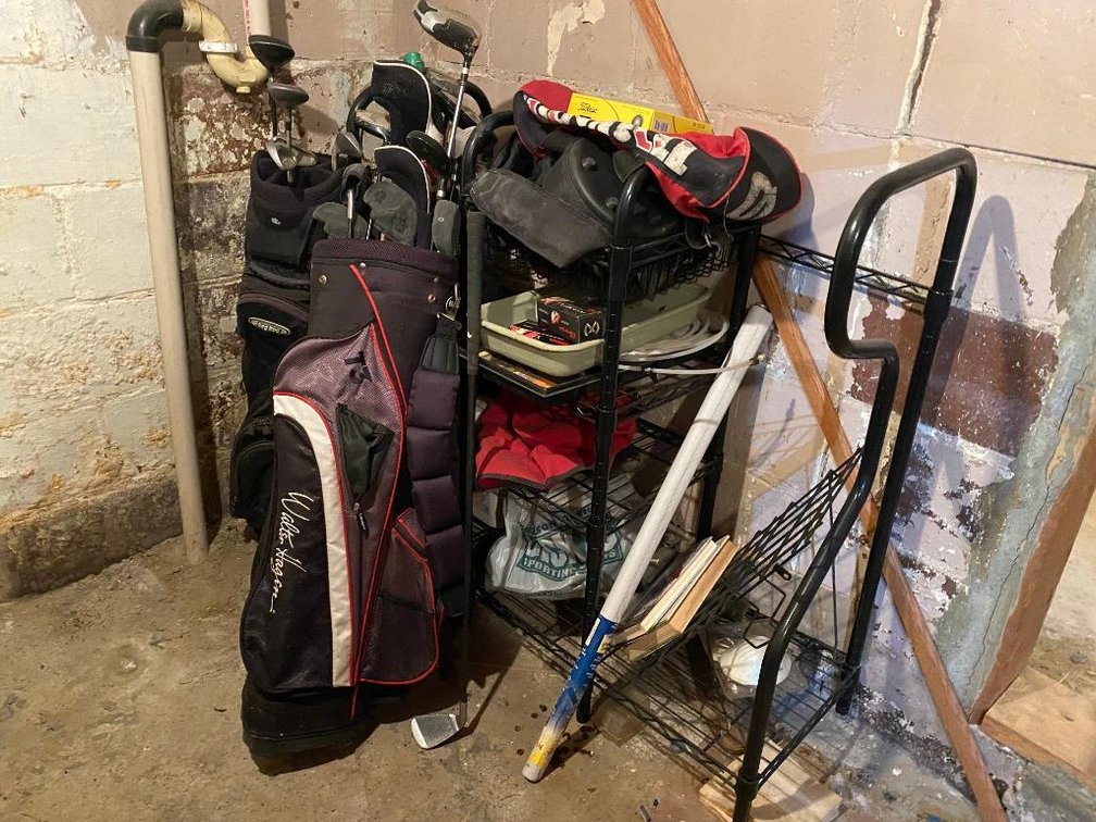 Lot of golf clubs and golfing items