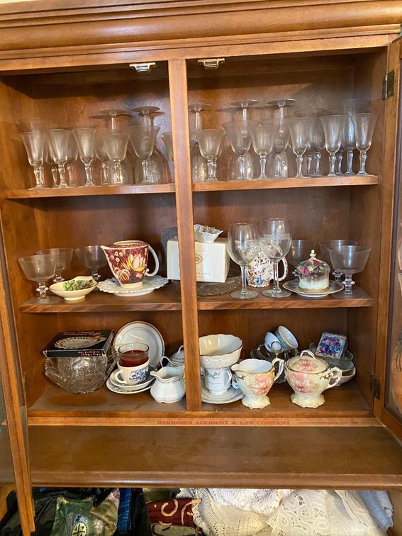Contents of the China cabinet:  Wine glasses, teapots, coffee cups, linens, etc.