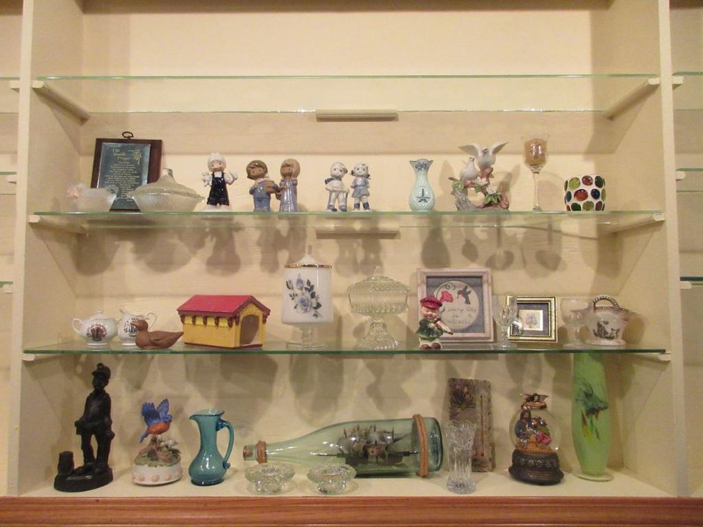 Contents of shelves:  Figurines, ship in a bottle, decorative glass pieces