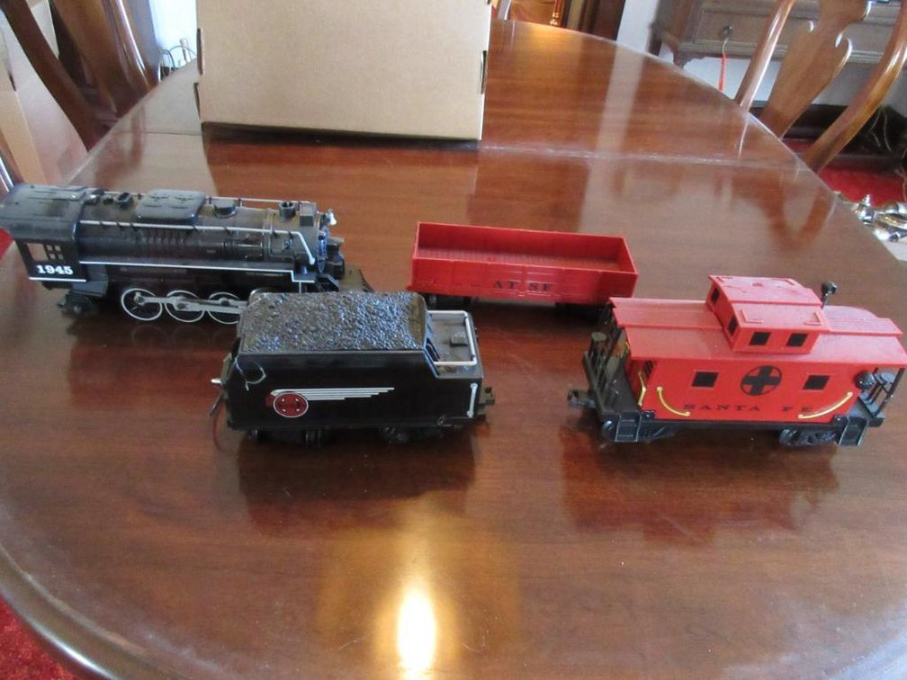 Lionel train engine, coal car, cargo car and caboose