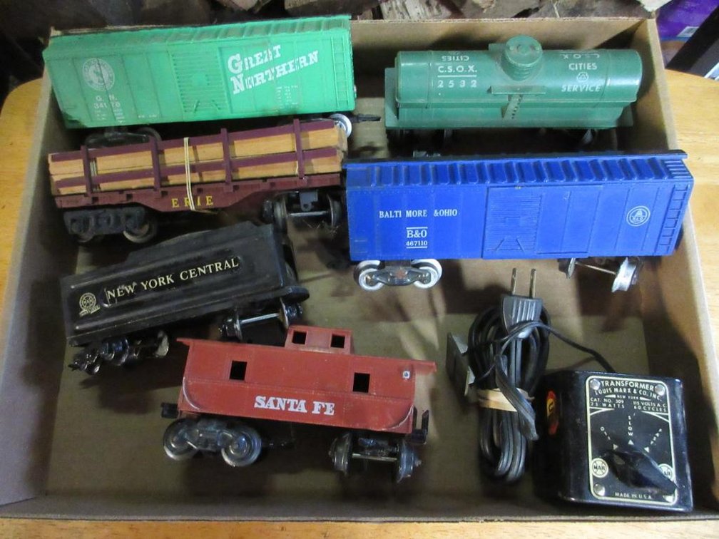 Some Marx train cars: Santa Fe caboose, Baltimore & Ohio box car #467110, New York Central Tender, Cities Service tanker #2532, Log & Erie flat car w/ logs, Great Northern box car #34178, Louis Marx transformer