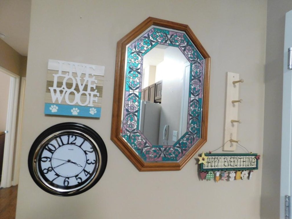 Wall grouping includes mirror, clock & decorative items