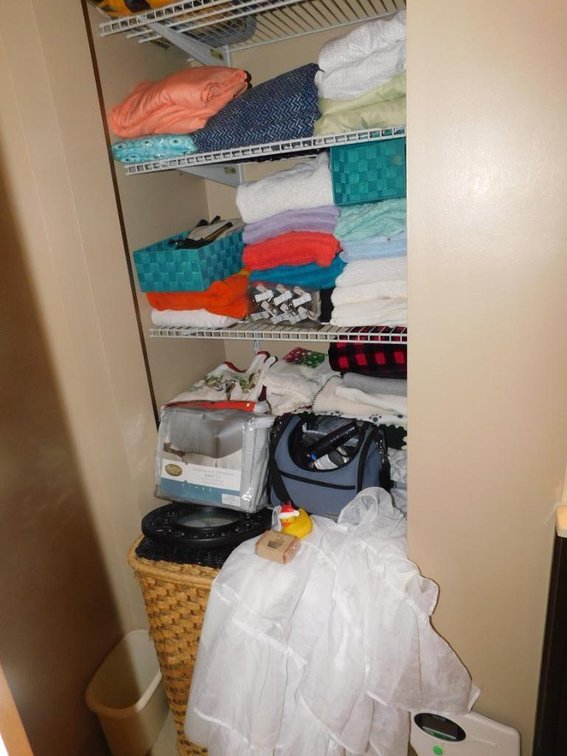 Contents of closet includes bed linens, towels, clock, hair dryer, mattress covers, scale & coverlets