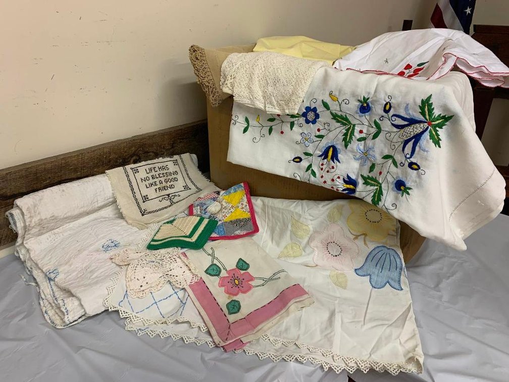 Collection of assorted linens; hand-stitched tablecloths, embroidered tablecloths, napkins, much loved quilt, etc.