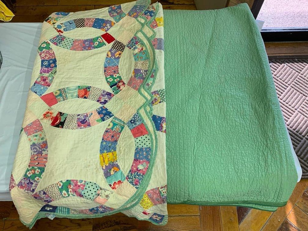 2 Quilts; one is a hand-stitched wedding ring quilt and a machine stitched quilt