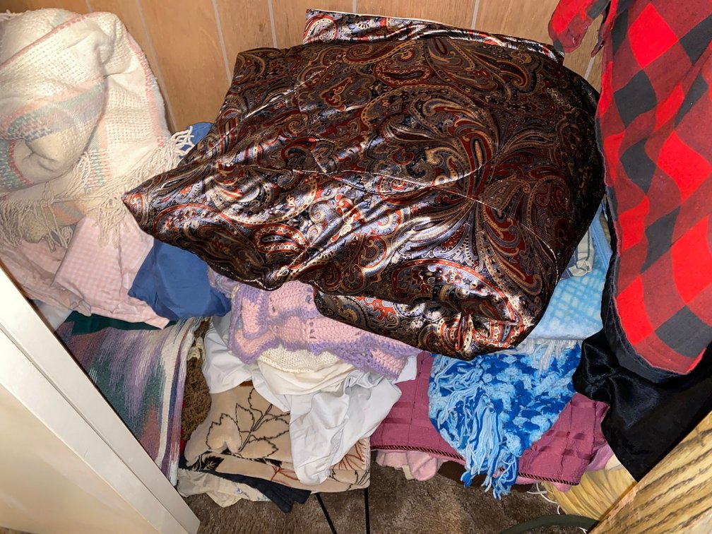 Contents of closet:  Afghans, towels, blankets, size XX clothes