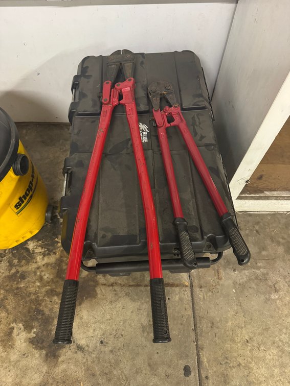 heavy-duty bolt cutters with long red handles.