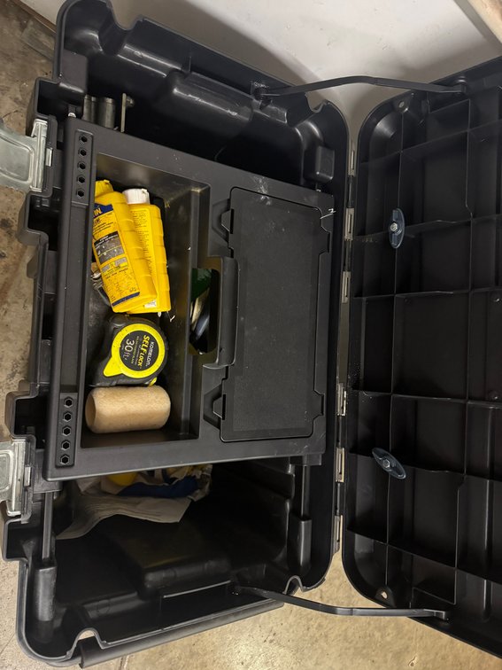 Portable hard tool case containing assorted measuring and hand tools.