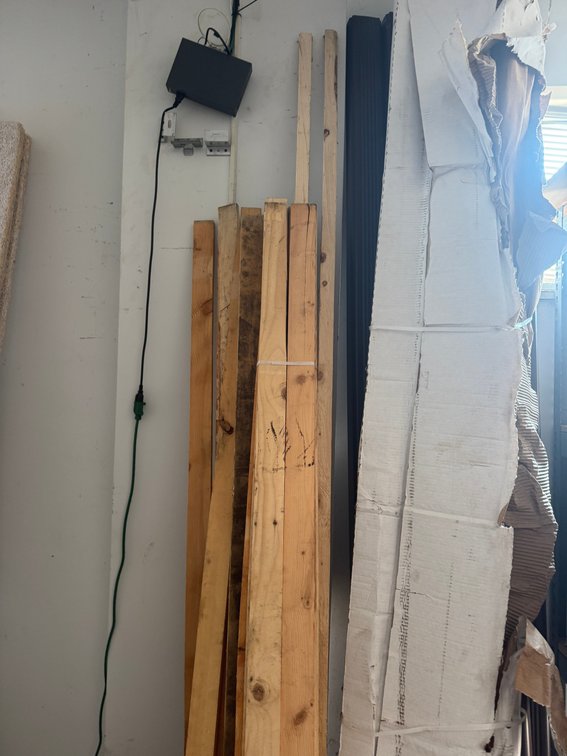 Assorted construction materials including lumber, insulation, and boxed material