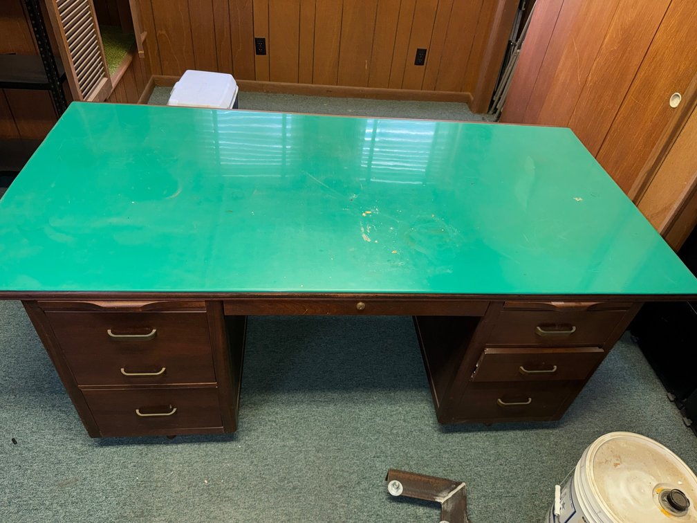 Wood executive desk with green work surface and dual drawer pedestals.