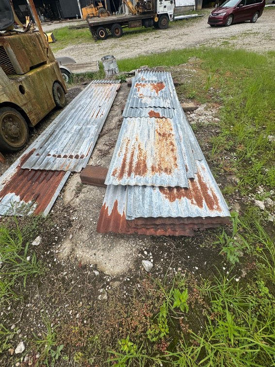 Stack of corrugated metal roofing/siding panels in assorted lengths.