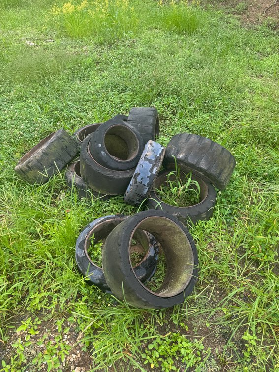 Assorted used industrial rubber tires/rings in various sizes.