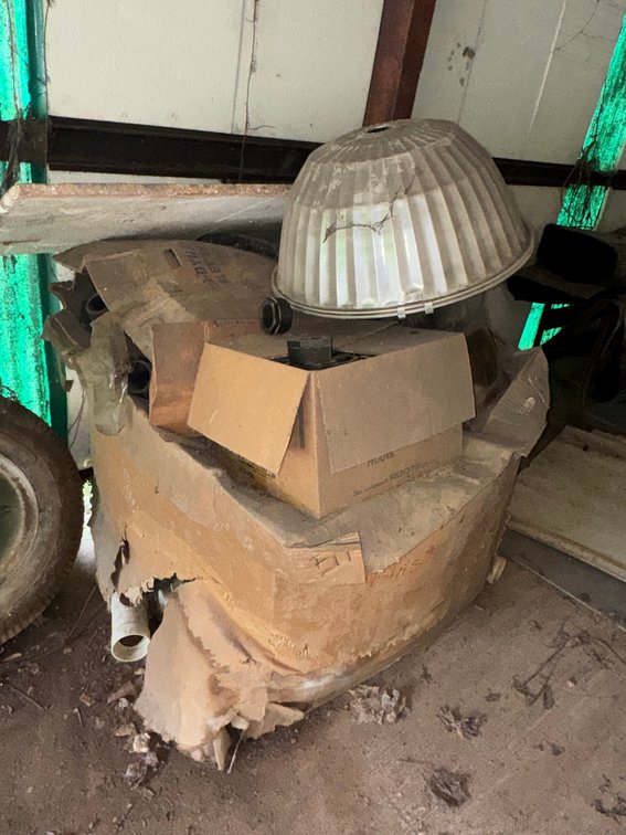 Assorted industrial pipe fittings, threaded couplings, PVC fittings, and a large industrial light fixture.