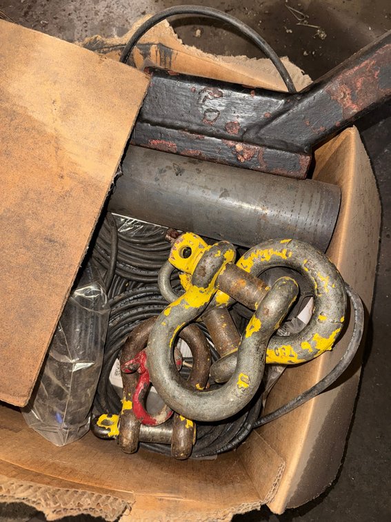 Assorted heavy-duty lifting and rigging hardware including shackles, hooks, and related components.