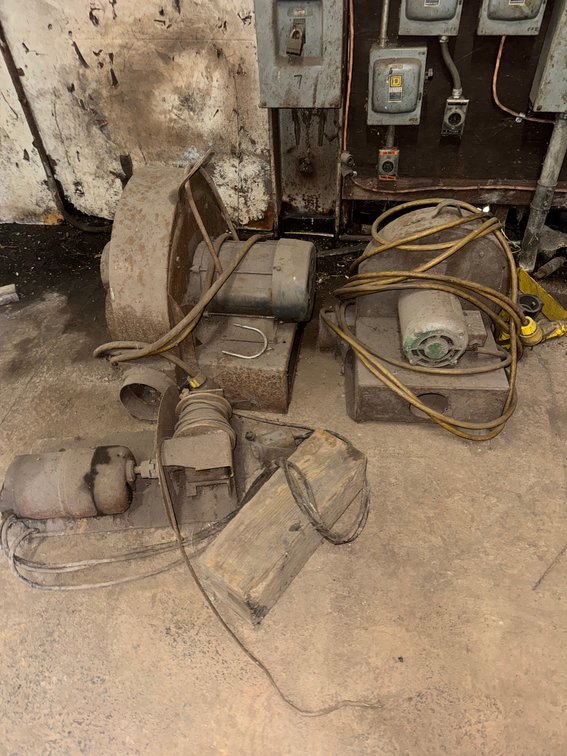 Assorted electric shop equipment including motors, blowers/fans, and power cords.
