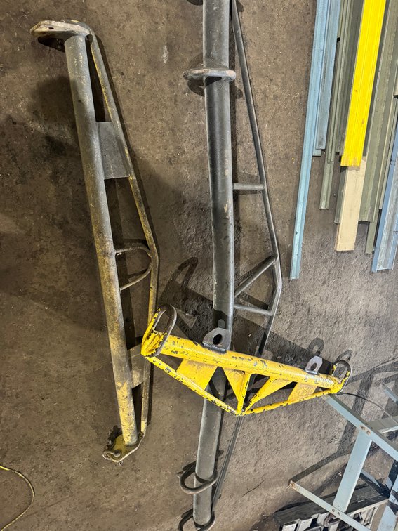 Assorted heavy-duty steel lifting/spreader bars and support frames with lifting eyes and mounting points.