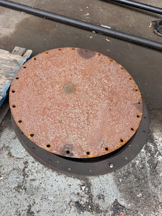 Large round steel flange/cover plate with evenly spaced bolt holes.